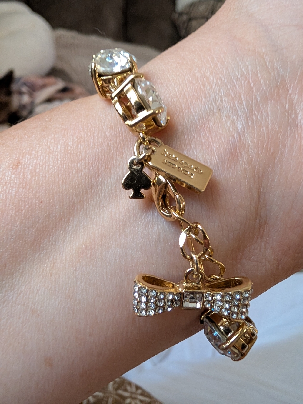 kate spade gold-tone crystal bow and charm bracelet